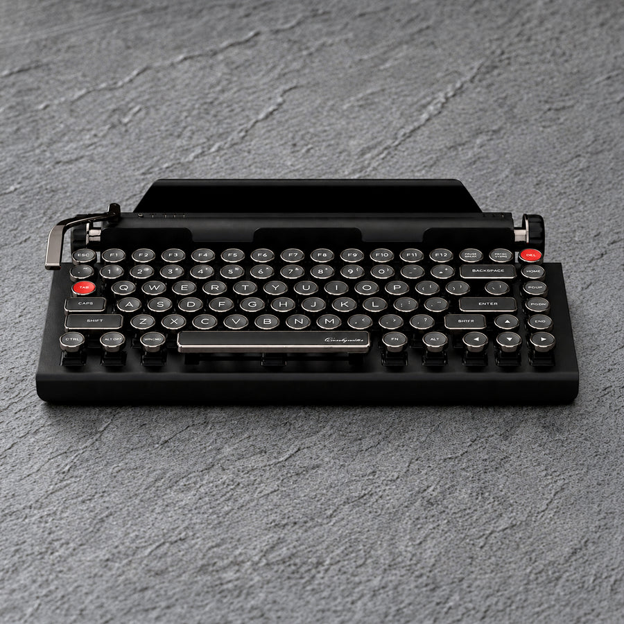 Qwerkywriter 2 Dark Chrome typewriter-style mechanical keyboard with round keys and a dark metallic finish.