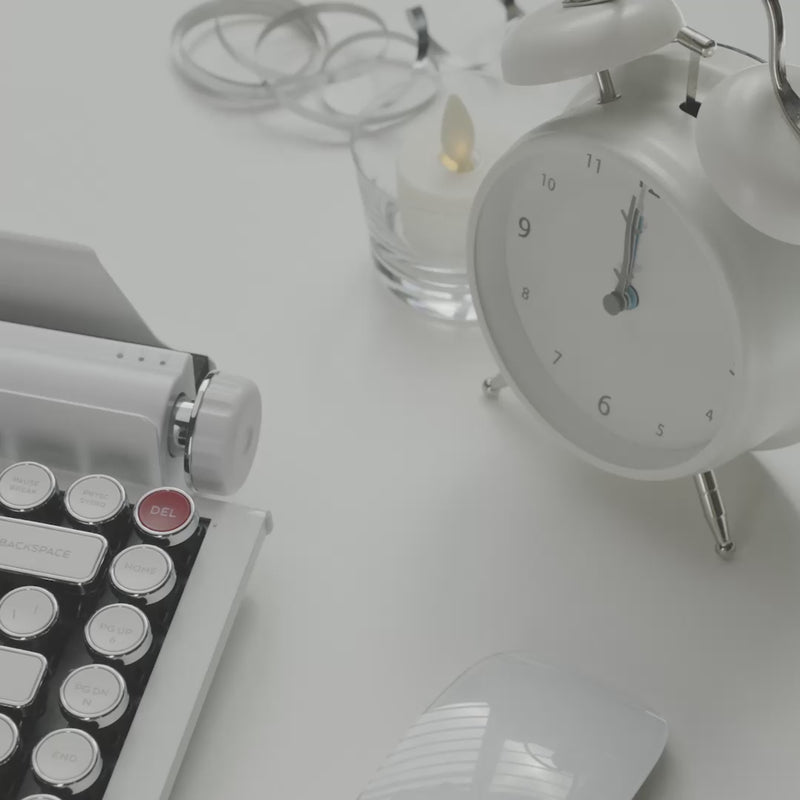 White Chrome Qwerkywriter Typewriter Retro Vintage Mechanical Keyboard, mouse, candle, and silver ribbon on a white desk.