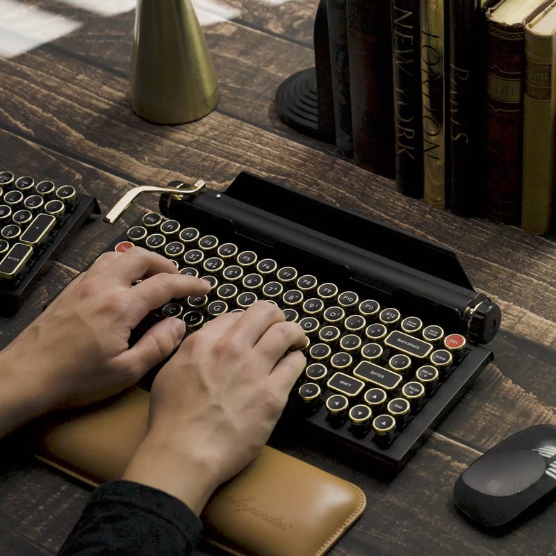 Video of a beautifully hand-assembled Qwerkywriter 2 in black and gold connected to an iPad, demonstrating its working return bar and scroll knob.