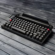Qwerkywriter typewriter keyboard best in class premium all aluminum body in anniversary dark chrome hero image on grey wood grain background