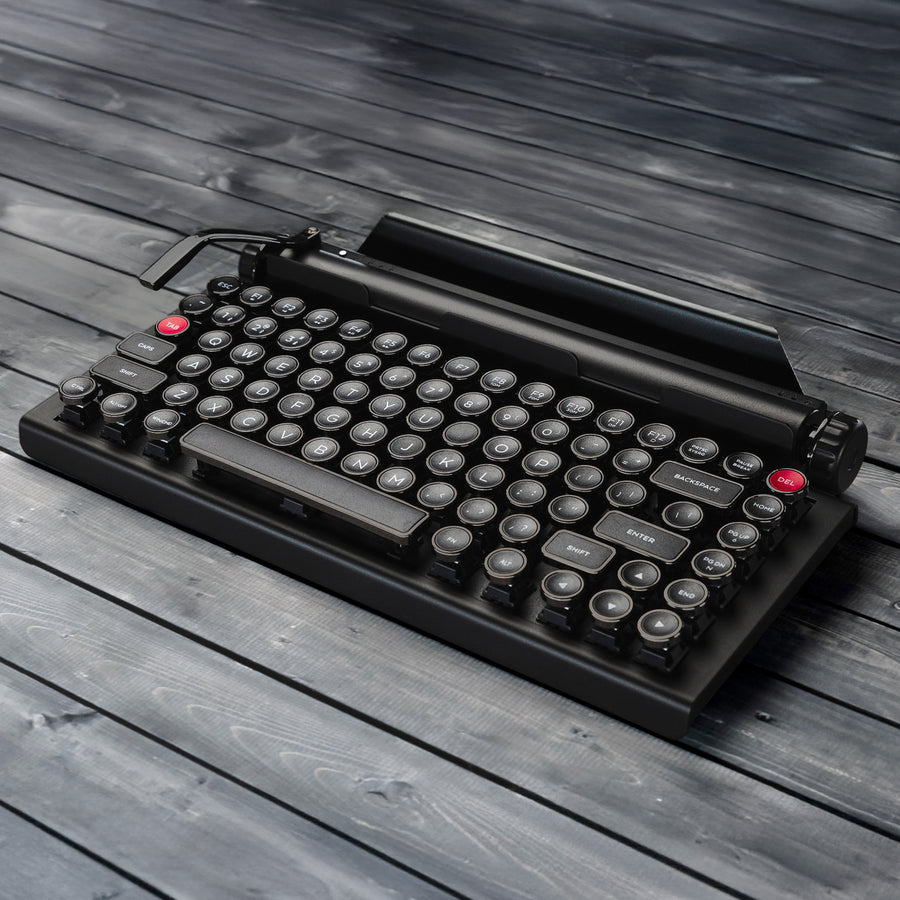Qwerkywriter typewriter keyboard best in class premium all aluminum body in anniversary dark chrome hero image on grey wood grain background