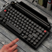 Qwerkywriter typewriter keyboard best in class premium all aluminum body in black chrome on grey wood grain background with silent linear cherry mx silver switches