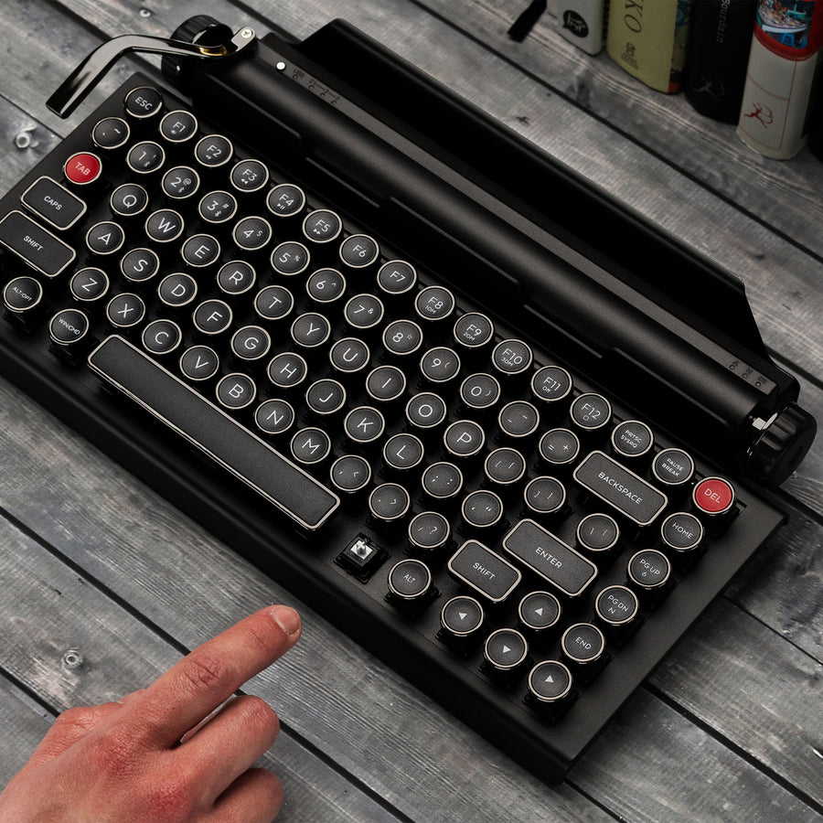 Qwerkywriter typewriter keyboard best in class premium all aluminum body in black chrome on grey wood grain background with silent linear cherry mx silver switches