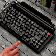 Qwerkywriter typewriter keyboard best in class premium all aluminum body in black chrome on grey wood grain background with silent linear cherry mx silver switches