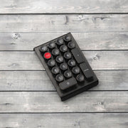 Qwerkywriter typewriter keyboard numkey numpad best in class premium all aluminum body in anniversary dark chrome left side view on dark wood grain