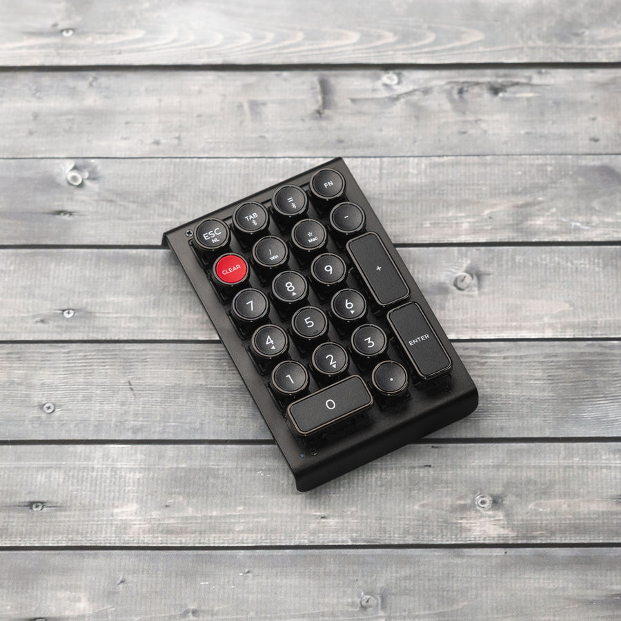 Qwerkywriter typewriter keyboard numkey numpad best in class premium all aluminum body in anniversary dark chrome left side view on dark wood grain