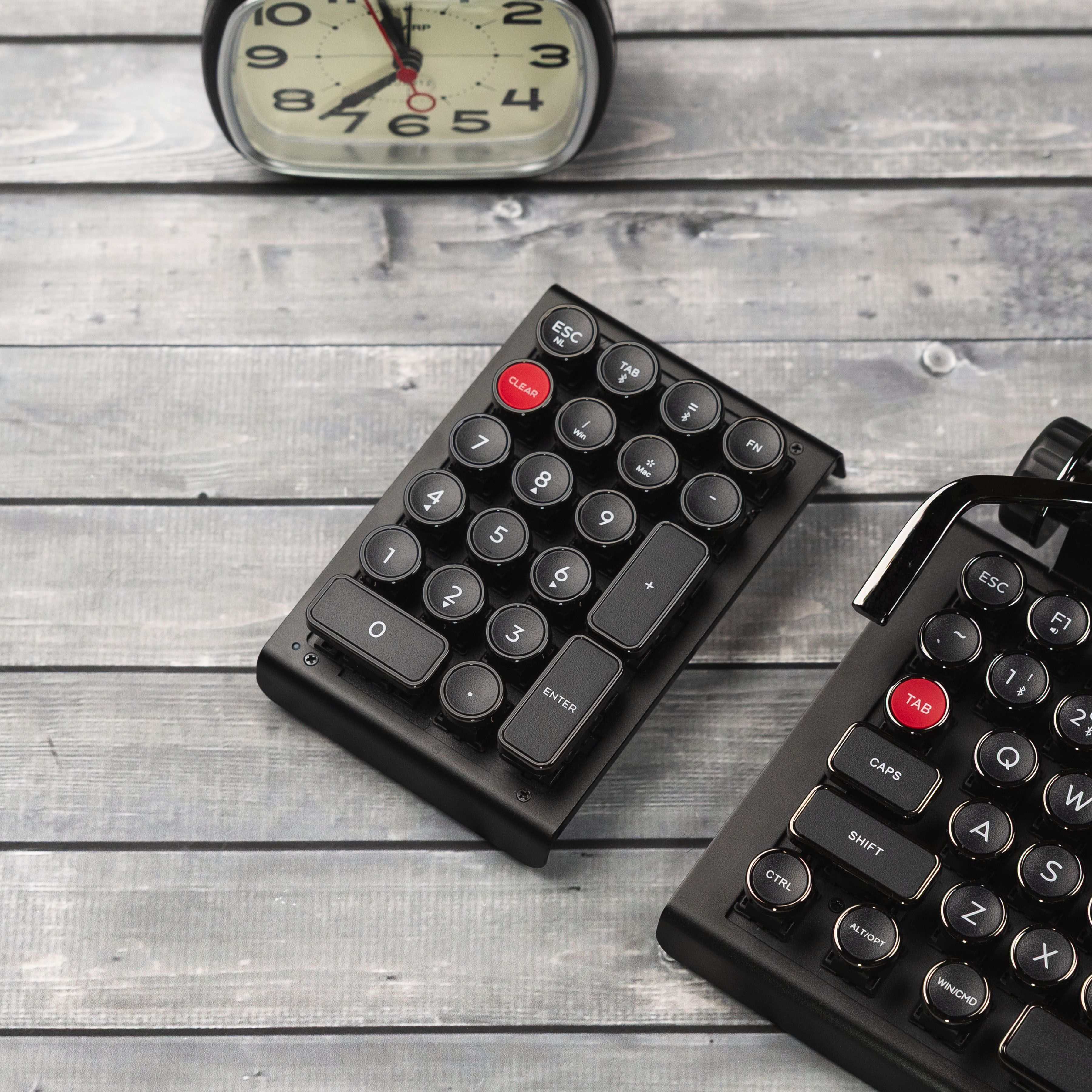 Qwerkywriter typewriter keyboard numkey numpad best in class premium all aluminum body in anniversary dark chrome right side view on dark wood grain with Qwerkywriter anniversary dark chrome typewriter keyboard and clock