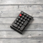 Qwerkywriter typewriter keyboard numkey numpad best in class premium all aluminum body in anniversary dark chrome right side view on dark wood grain 