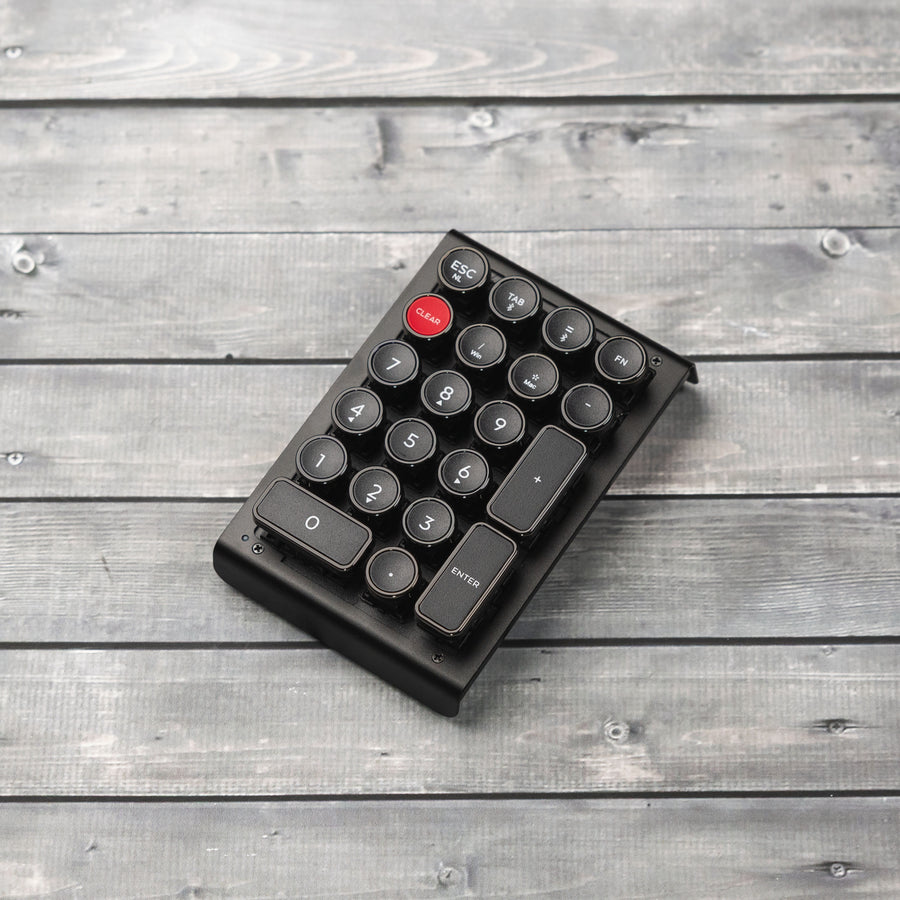 Qwerkywriter typewriter keyboard numkey numpad best in class premium all aluminum body in anniversary dark chrome right side view on dark wood grain 