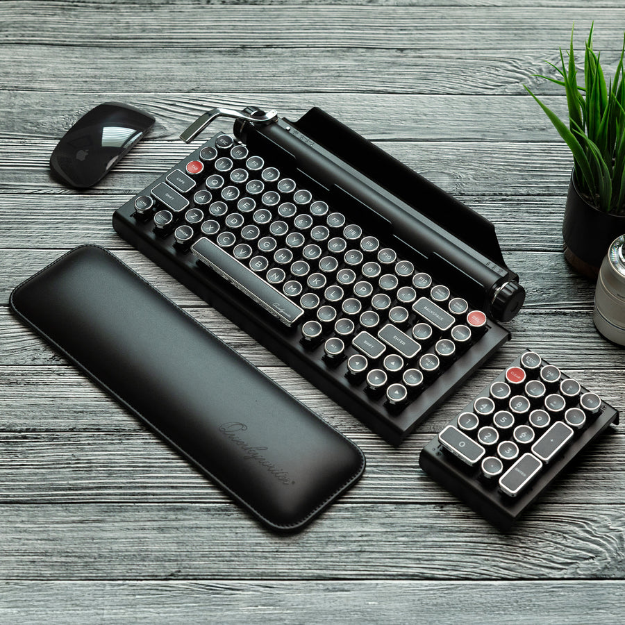 Qwerkywriter typewriter keyboard best in class premium all aluminum body in white chrome on grey wood grain background complete desktop with Qwerkywriter Official Wrist Rest and Black Chrome Numkey