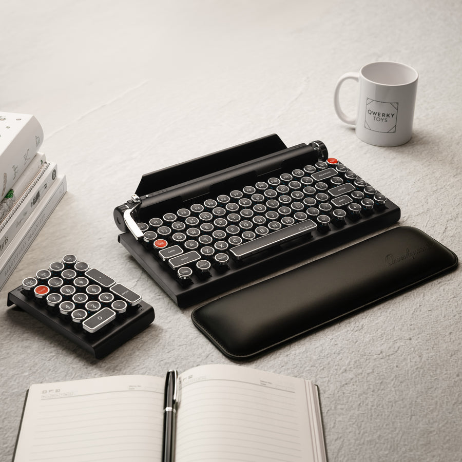 Qwerkywriter typewriter keyboard best in class premium all aluminum body in white chrome on grey wood grain background complete desktop with Qwerkywriter Official Wrist Rest and Black Chrome Numkey