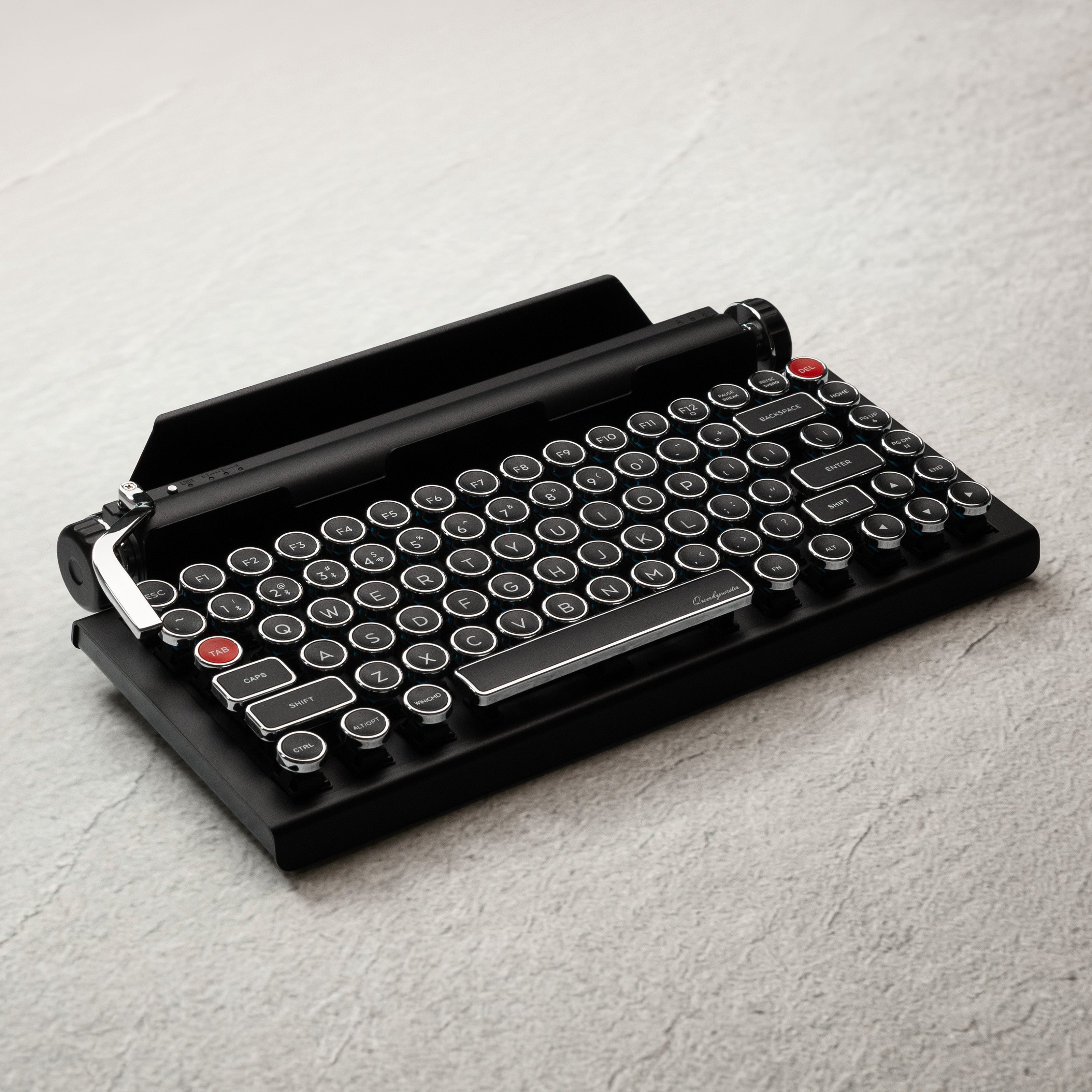 Qwerkywriter typewriter keyboard best in class premium all aluminum body in black chrome on grey wood grain background with hot swap tool and cherry mx blue switch hero image