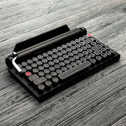 Qwerkywriter typewriter keyboard best in class premium all aluminum body in black chrome hero image on grey wood grain background