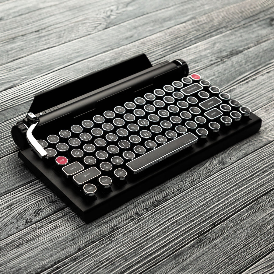 Qwerkywriter typewriter keyboard best in class premium all aluminum body in black chrome hero image on grey wood grain background