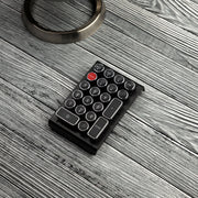 Qwerkywriter typewriter keyboard numkey numpad best in class premium all aluminum body in black chrome left view on grey wood grain
