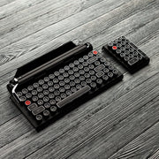 Qwerkywriter typewriter keyboard numkey numpad best in class premium all aluminum body in black chrome leftside view on grey wood grain with the qwerkywriter