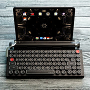 qwerkywriter typewriter keyboard best in class premium all aluminum body in black chrome on grey wood grain background with tablet stand heavy duty accommodate up to 13 inch tablet and 5/8 inches thick