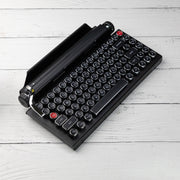 Qwerkywriter typewriter keyboard best in class premium all aluminum body in black chrome on white wood background US ANSI layout