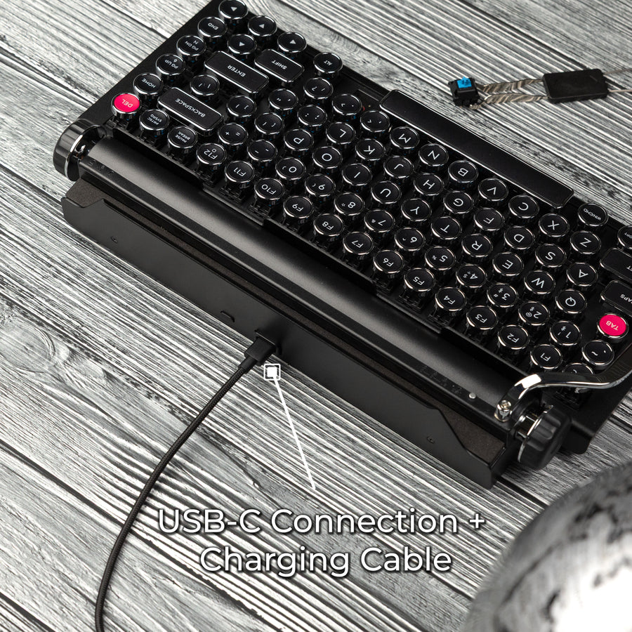 Qwerkywriter typewriter keyboard best in class premium all aluminum body in black chrome on grey wood grain background usb-c connection and charging cable

