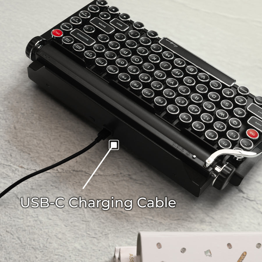 Qwerkywriter typewriter keyboard best in class premium all aluminum body in black chrome on grey wood grain background usb-c connection and charging cable
