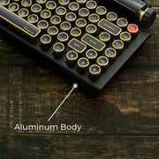 Qwerkywriter typewriter keyboard best in class premium all aluminum body in black gold on brown wood grain background aluminum chassis body