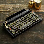 Qwerkywriter typewriter keyboard best in class premium all aluminum body in black gold hero image on brown wood grain background Alternate Angle

