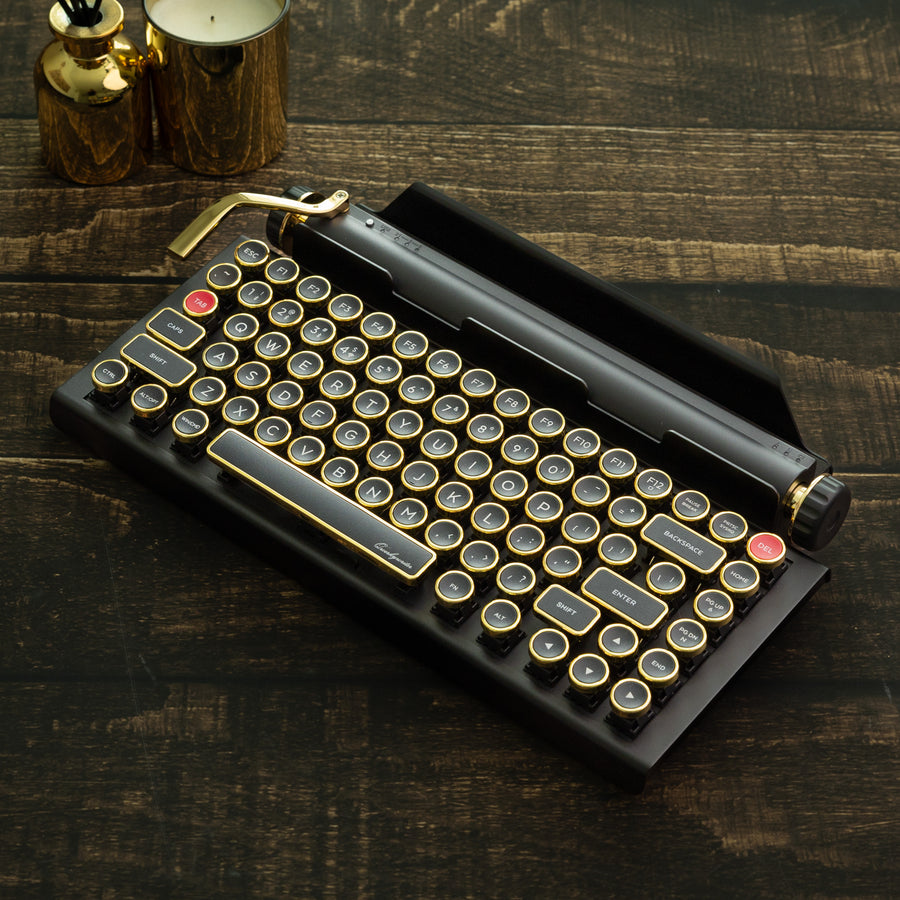 Qwerkywriter typewriter keyboard best in class premium all aluminum body in black gold hero image on brown wood grain background