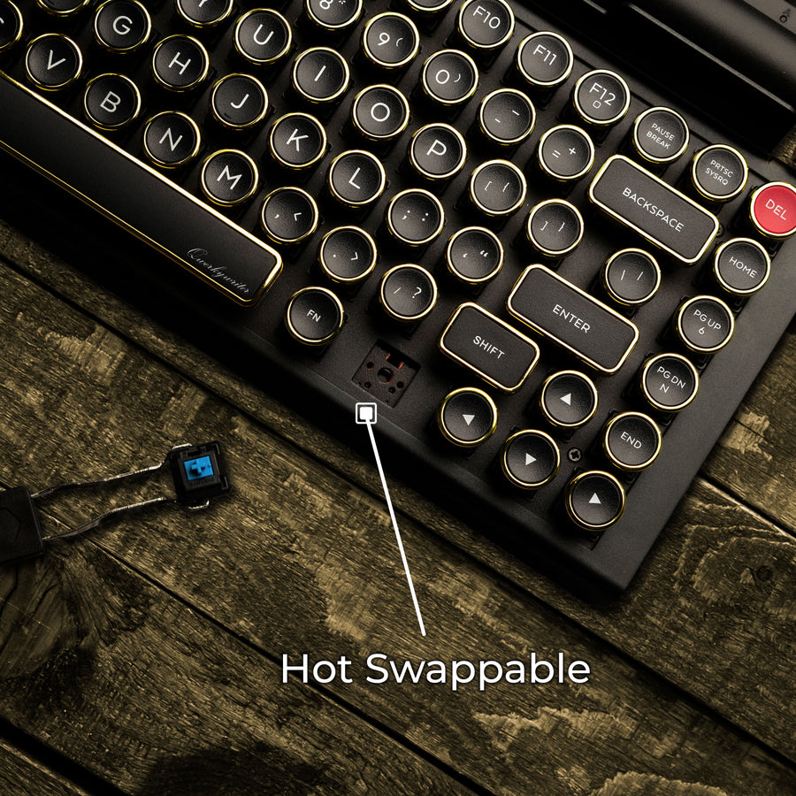 Qwerkywriter typewriter keyboard best in class premium all aluminum body in black gold close up view of hot swappable switches on brown wood grain background