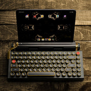Qwerkywriter typewriter keyboard best in class premium all aluminum body in black gold top view of Ipad tablet on brown wood grain background
