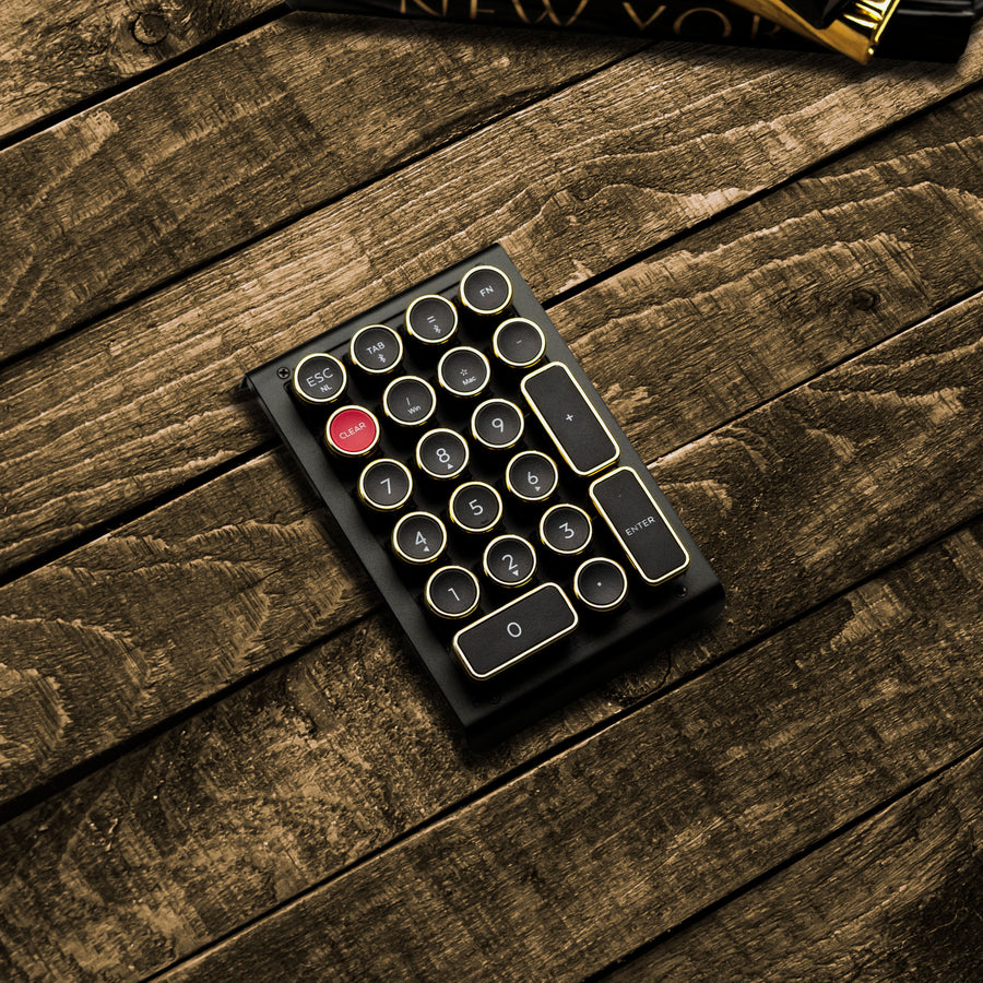 Qwerkywriter typewriter keyboard numkey numpad best in class premium all aluminum body in black gold right side view on brown wood grain