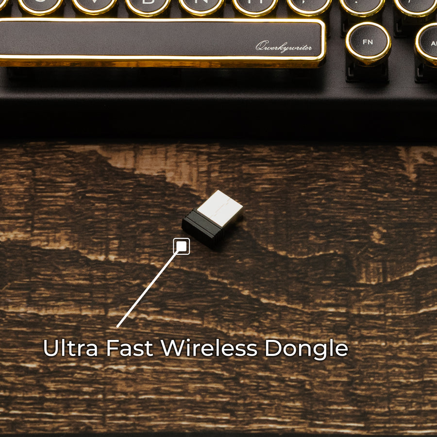 Qwerkywriter typewriter keyboard best in class premium all aluminum body in black gold on brown wood grain background ultra fast wireless dongle lagless no lag