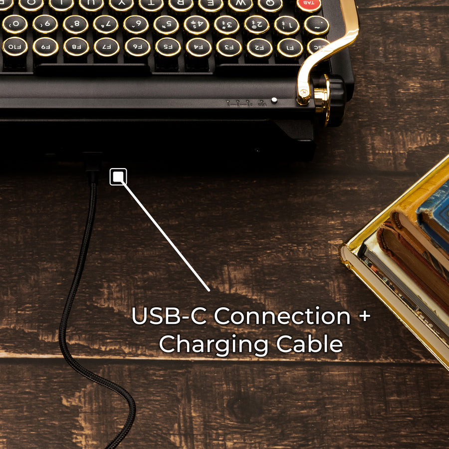 Qwerkywriter typewriter keyboard best in class premium all aluminum body in black gold close up rear back view of USB-C connection and charging cable on brown wood grain background