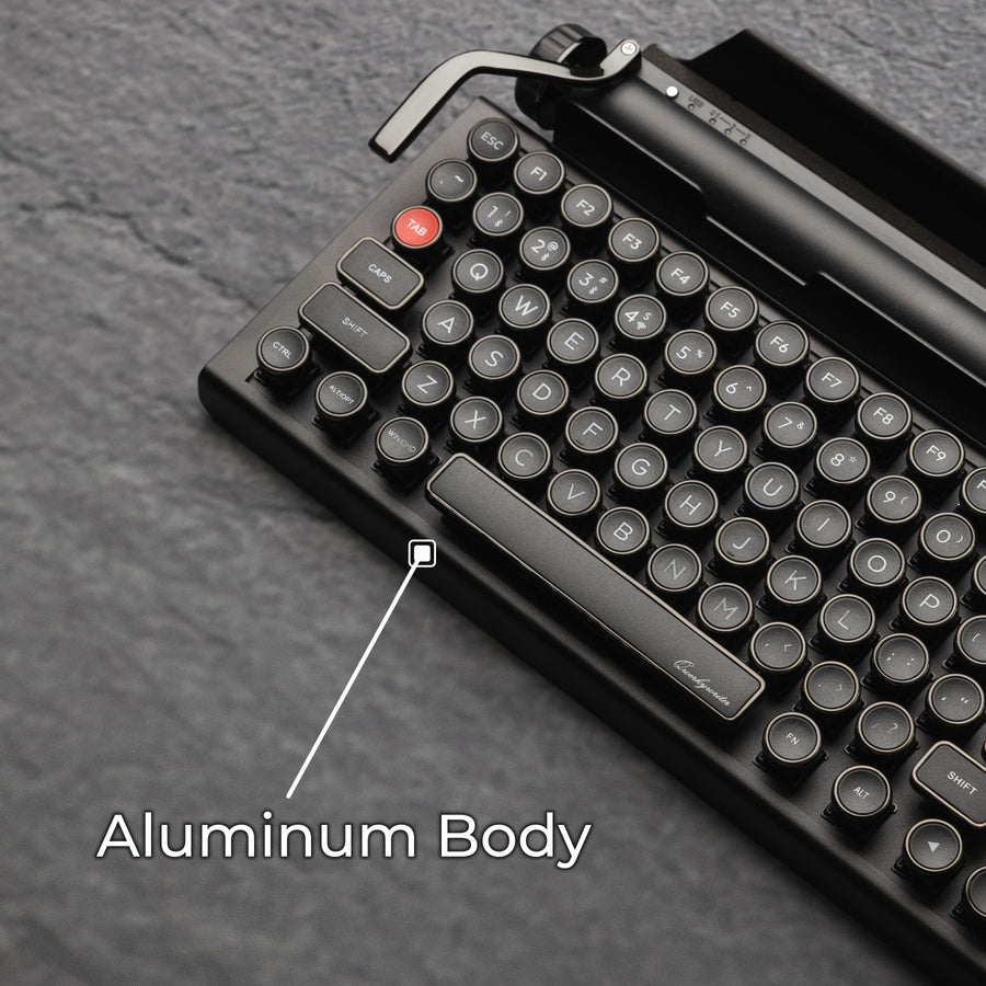 Qwerkywriter typewriter keyboard best in class premium all aluminum body in dark chrome on grey stone slab background aluminum chassis body