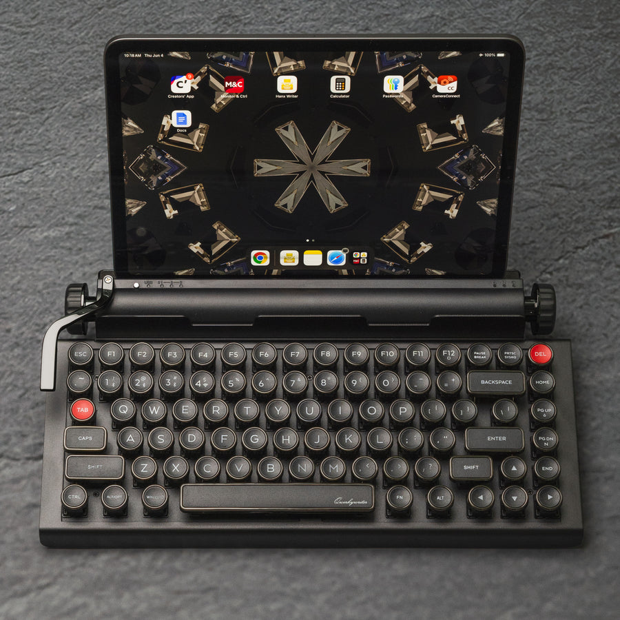 Qwerkywriter typewriter keyboard best in class premium all aluminum body in dark chrome top view of Ipad tablet on grey stone slab background