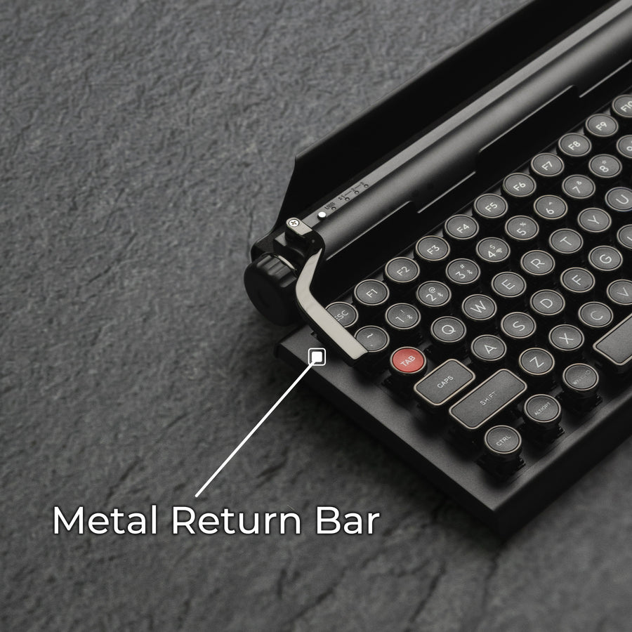 Qwerkywriter typewriter keyboard best in class premium all aluminum body in dark chrome on grey stone slab background cast metal macro programmable return bar