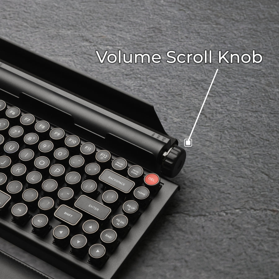 Qwerkywriter typewriter keyboard best in class premium all aluminum body in dark chrome close up view of volume scroll knob on grey stone slab background