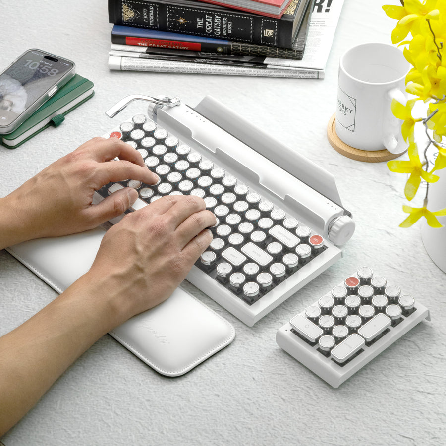 Qwerkywriter typewriter keyboard best in class premium all aluminum body in white chrome on white background person typing
