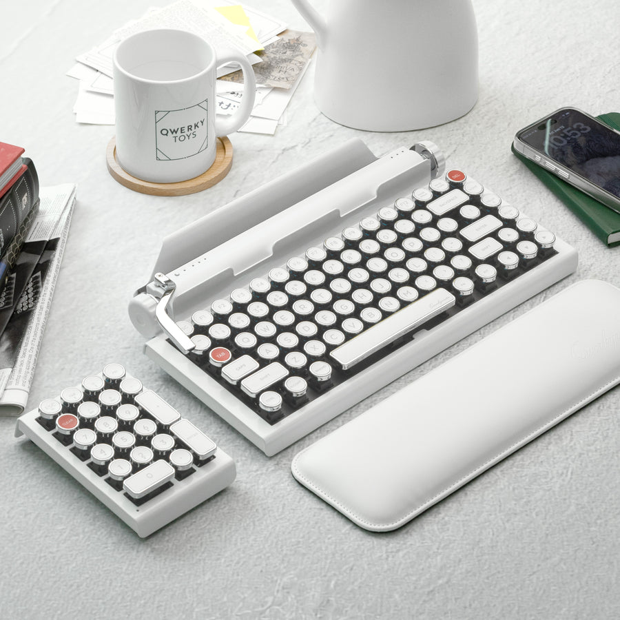 Qwerkywriter typewriter keyboard best in class premium all aluminum body in white chrome on light background desktop with coffee and books