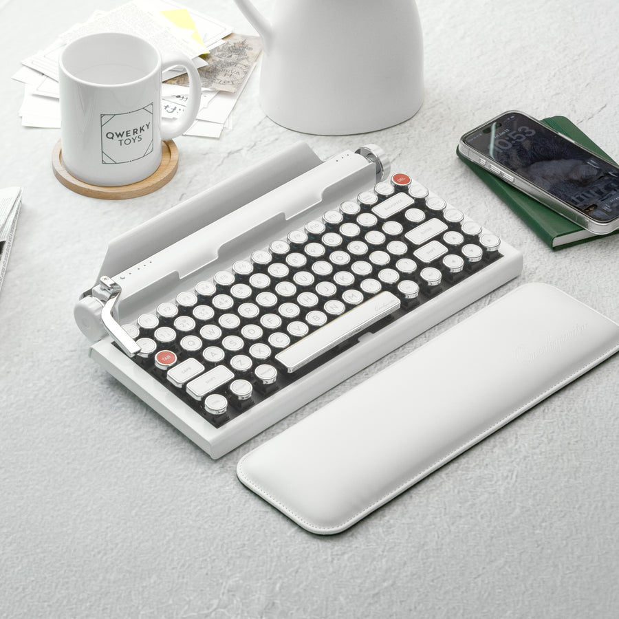 Qwerkywriter typewriter keyboard best in class premium all aluminum body in white chrome on light background desktop with coffee and books