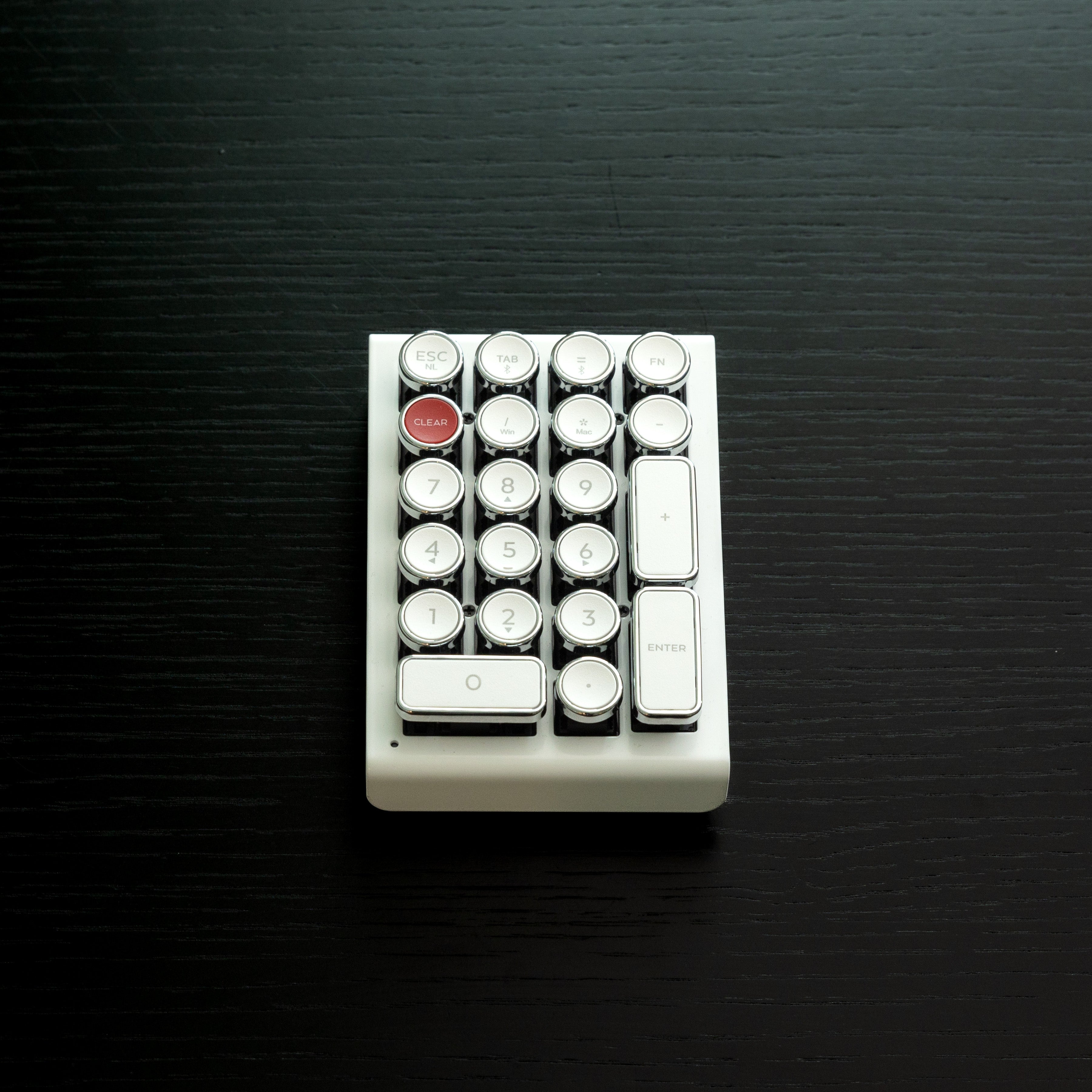 Qwerkywriter typewriter keyboard numkey numpad best in class premium all aluminum body in white chrome front view on black wood grain 