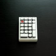 Qwerkywriter typewriter keyboard numkey numpad best in class premium all aluminum body in white chrome front view on black wood grain 