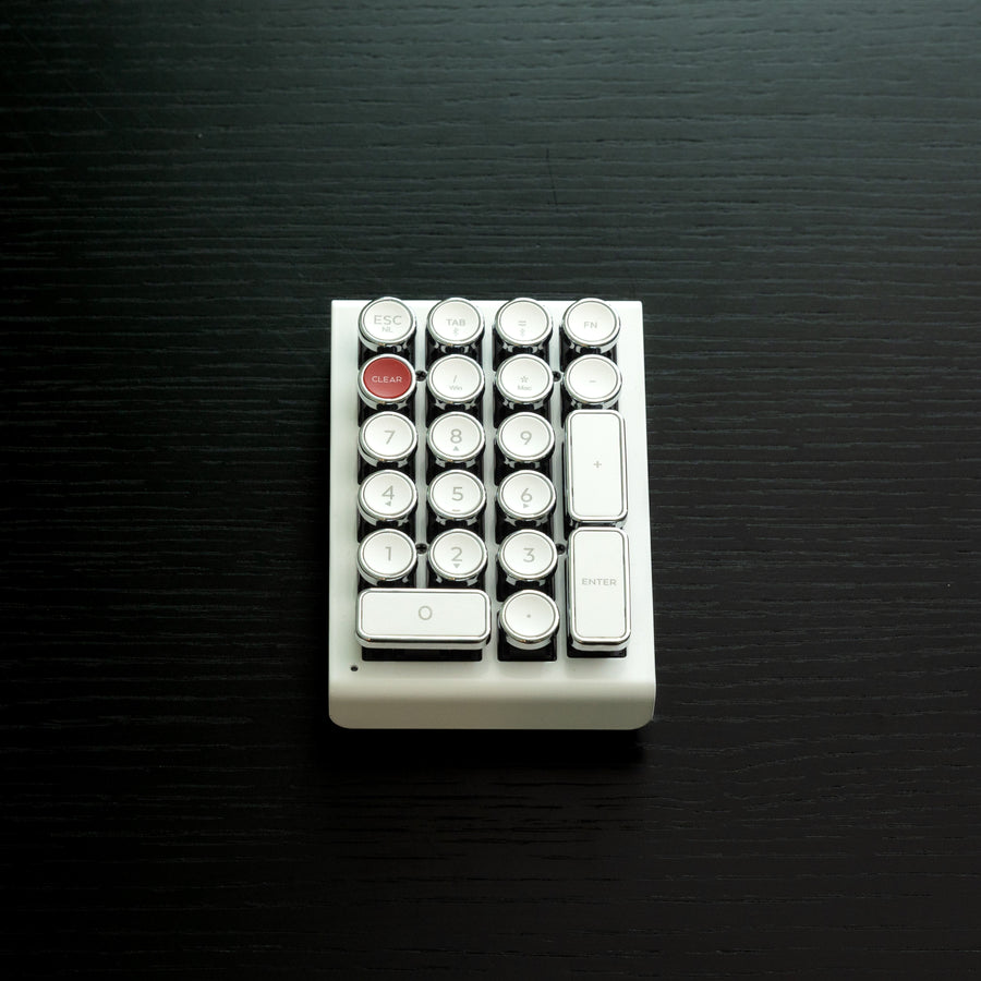 Qwerkywriter typewriter keyboard numkey numpad best in class premium all aluminum body in white chrome front view on black wood grain 