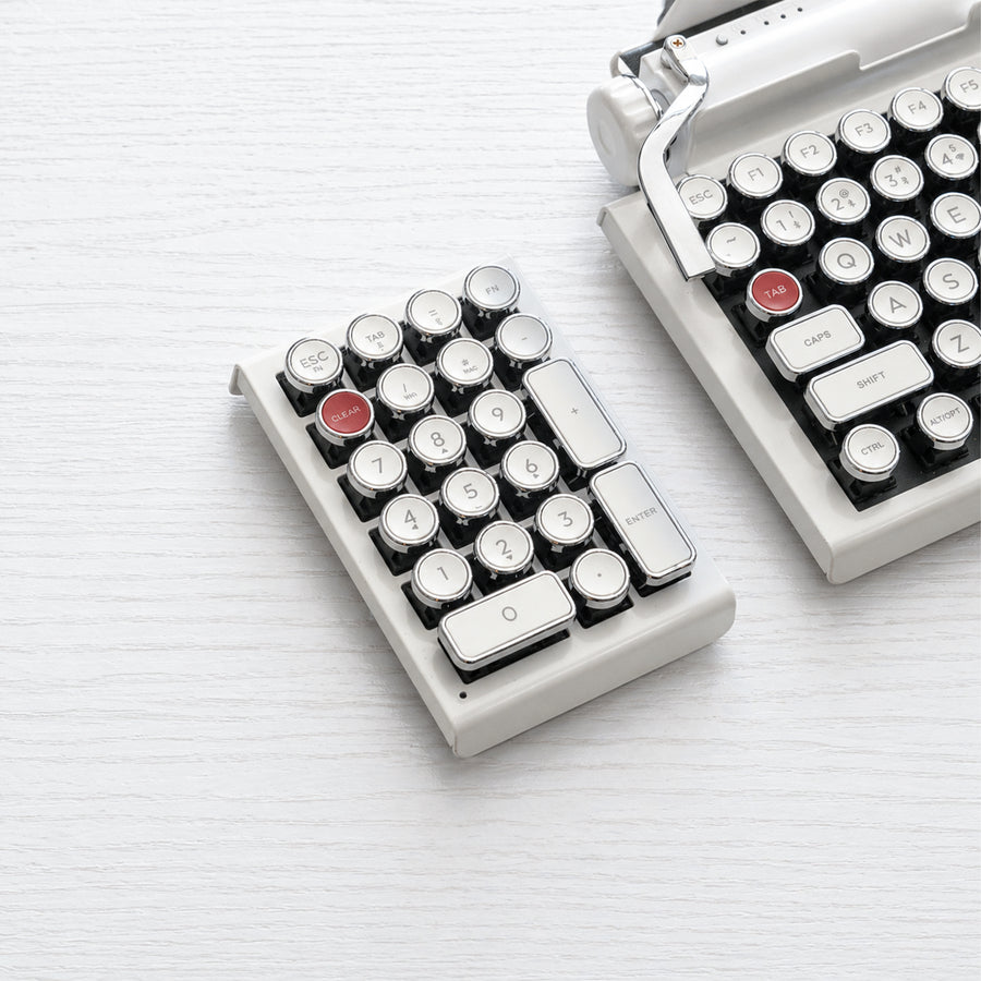 Qwerkywriter typewriter keyboard numkey numpad best in class premium all aluminum body in white chrome left side view on white wood grain with Qwerkywriter white chrome typewriter keyboard