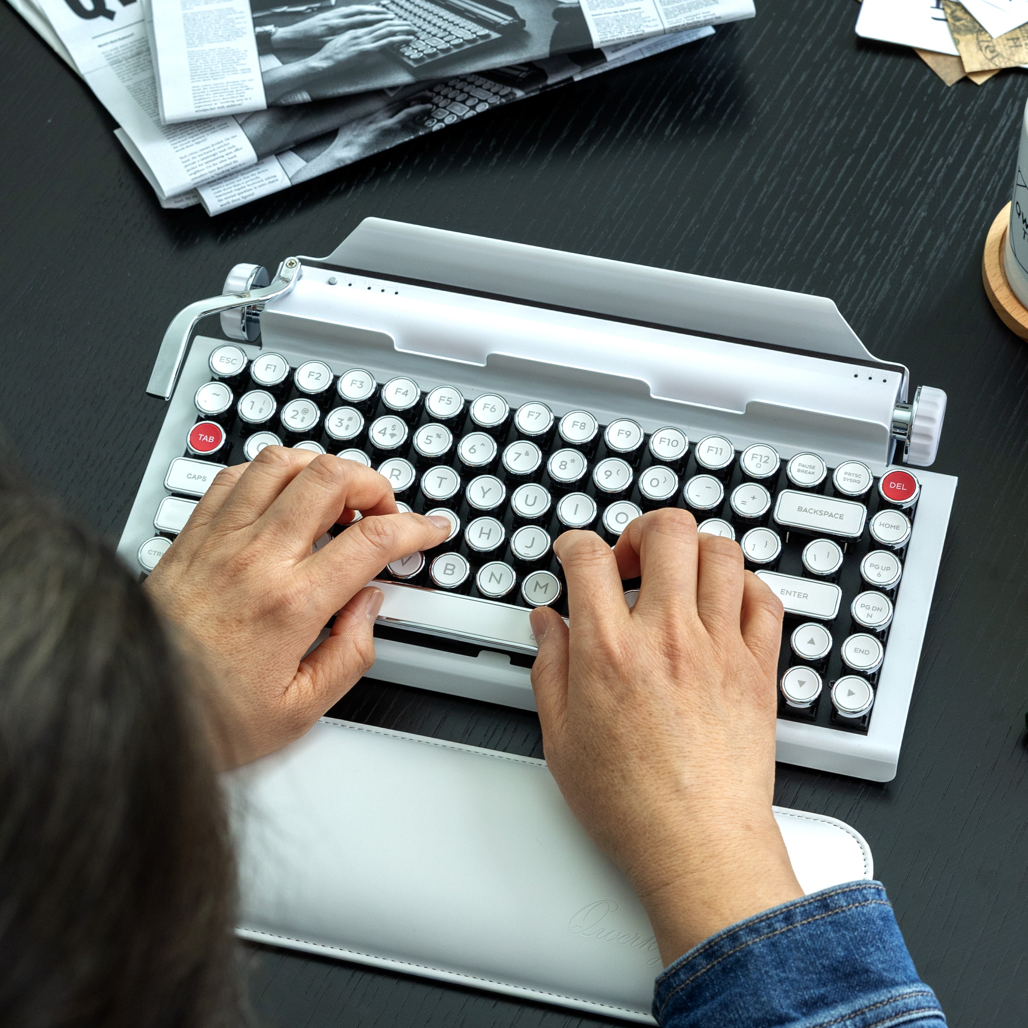Qwerkywriter typewriter keyboard best in class premium all aluminum body in white chrome on dark wood background person typing
