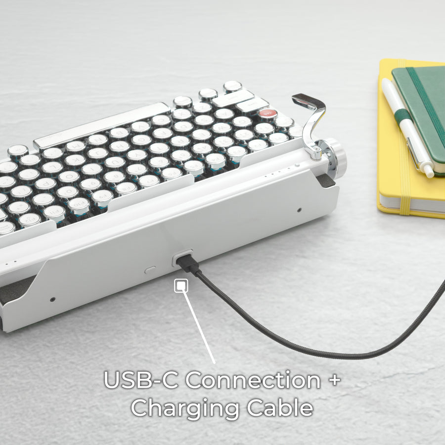 Qwerkywriter typewriter keyboard best in class premium all aluminum body in white chrome on dark wood background with USB C charging and connection cable with dongle
