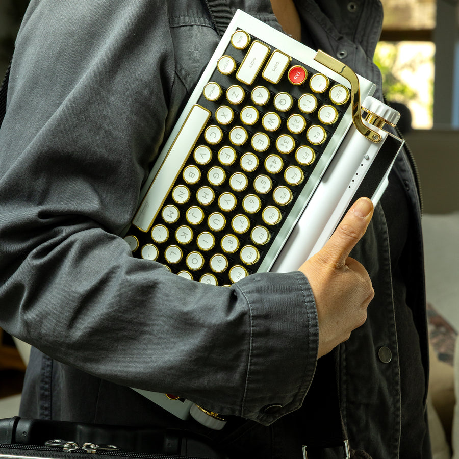 Qwerkywriter typewriter keyboard best in class premium all aluminum body in white gold with jean jacket walking and carrying