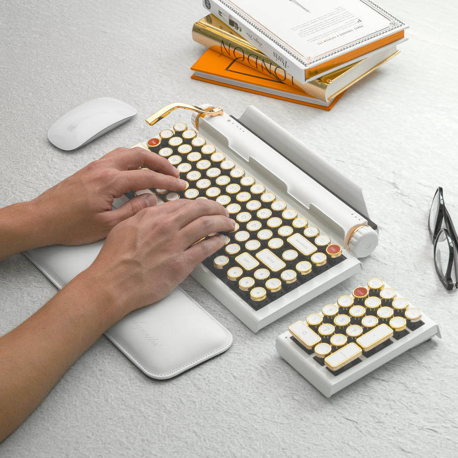 Qwerkywriter typewriter keyboard best in class premium all aluminum body in white gold typing on light stone background desk