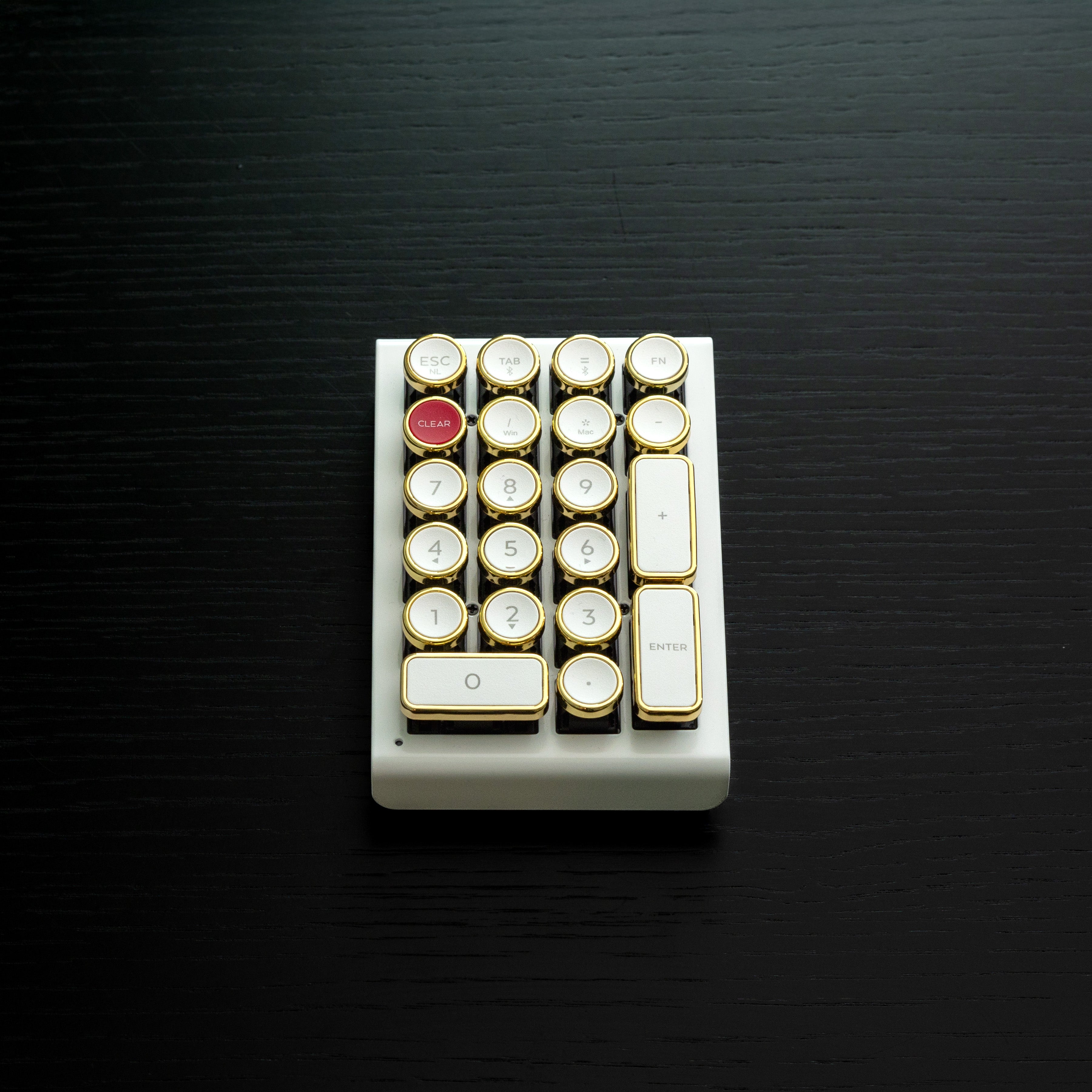 Qwerkywriter typewriter keyboard numkey numpad best in class premium all aluminum body in white gold front view on black wood grain 