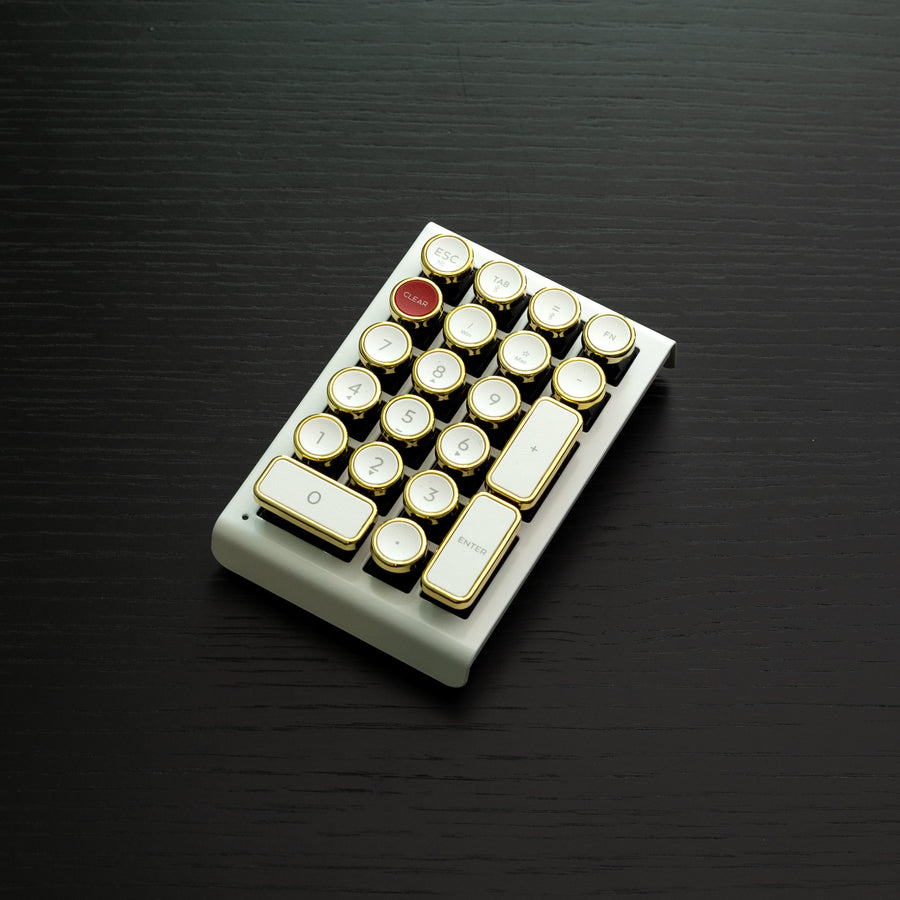 Qwerkywriter typewriter keyboard numkey numpad best in class premium all aluminum body in white gold left side view on black wood grain 