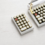 Qwerkywriter typewriter keyboard numkey numpad best in class premium all aluminum body in white gold front view on white wood grain 
